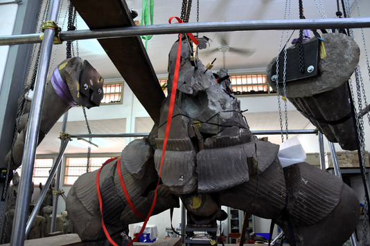 Assemblage des blocs et fragments du buste, du bassin, des bras et des jambes, maintenus par des sangles avant leur fixation, Conservation d’Angkor, Cambodge (Eric Boudonneau, 2023)