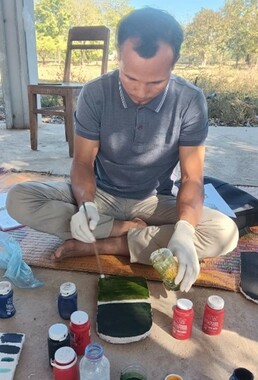 Bounsouang Senphaseuth effectuant les tests de peintures - Décembre 2025 (© Projet CHAMPA).