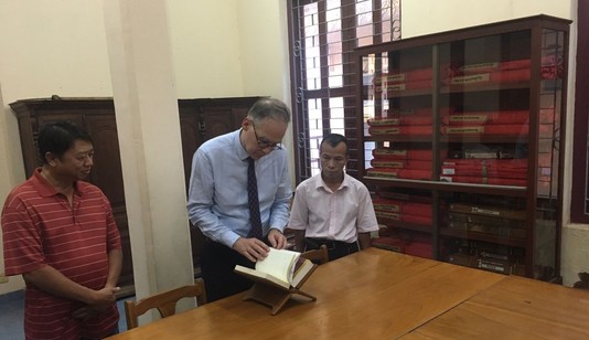 Entouré du personnel du FEMC, Nicolas Fiévé consulte les volumes de l'Inventaire provisoire des manuscrits du Cambodge